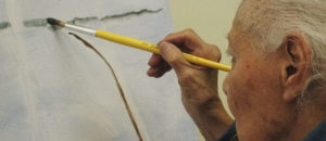 An old man is painting