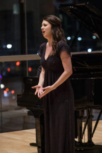 A girl in a black dress singing